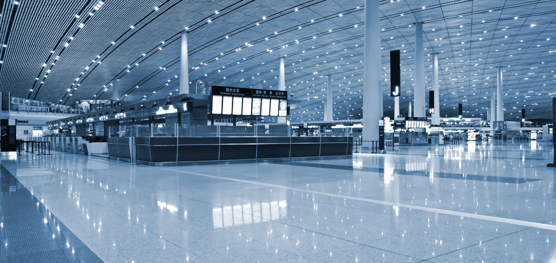 A large airport terminal with luggage carts and signs.