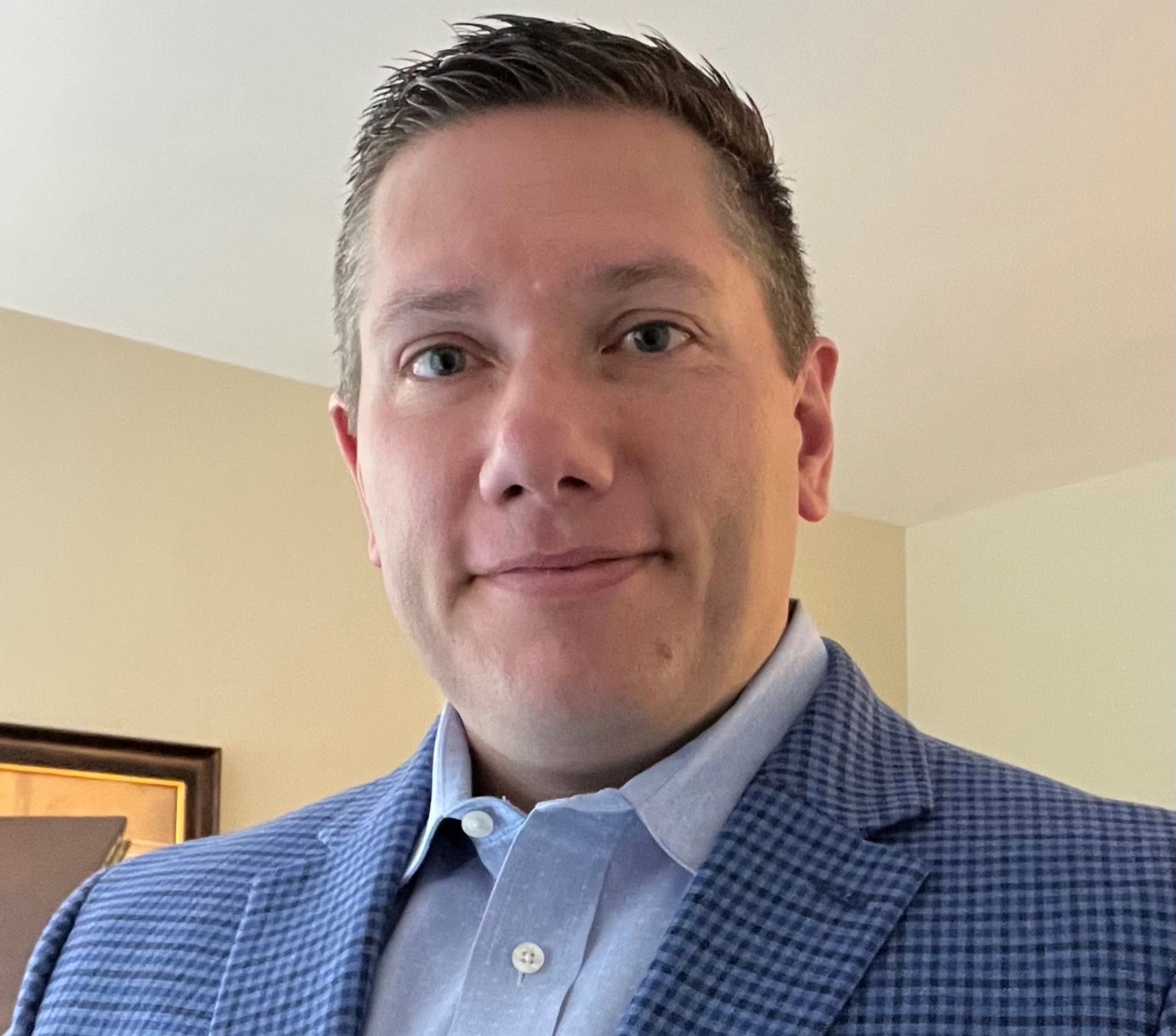 A man in a blue jacket and white shirt.