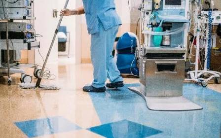 Hospital worker mopping clean floor.