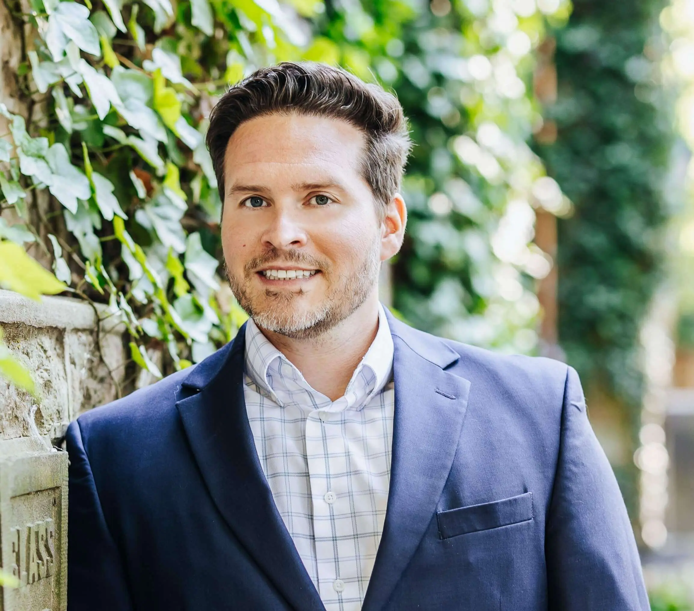 A man in a suit standing next to a wall.